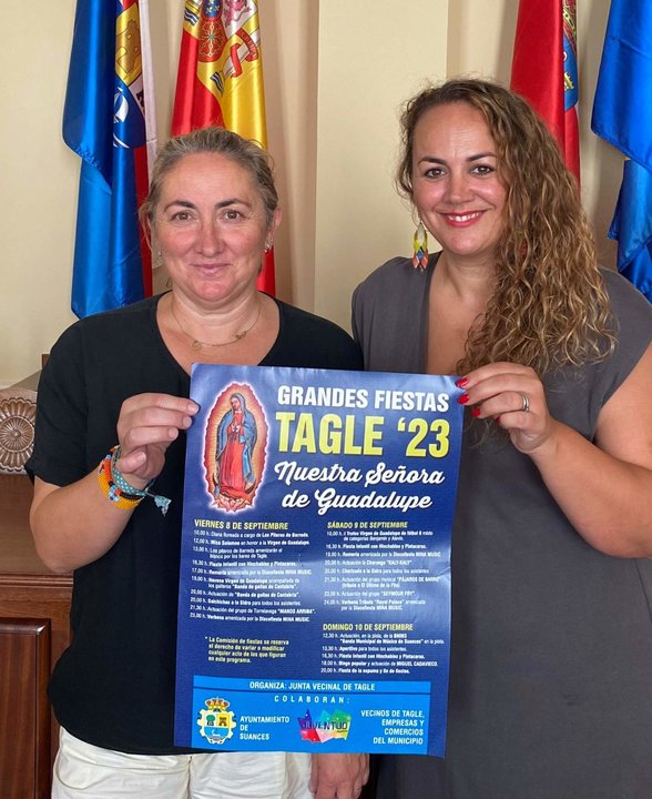 Rebeca Pernía y Raquel Fernández con el cartel de fiestas de Tagle 2023