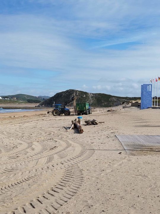 Tareas de limpieza de la arena en la playa de La Concha de Suances