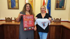La concejala Raquel Fern&aacute;ndez y la presidenta de la Junta Vecinal, Rebeca Pern&iacute;a, con el cartel y el pa&ntilde;uelo de las fiestas de Guadalupe